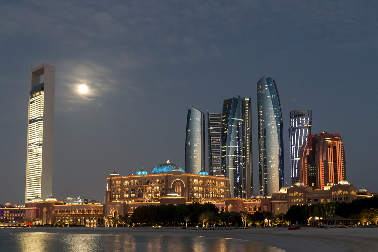 The Abu Dhabi skyline at night, representing sovereign capital and global investment in AI infrastructure.