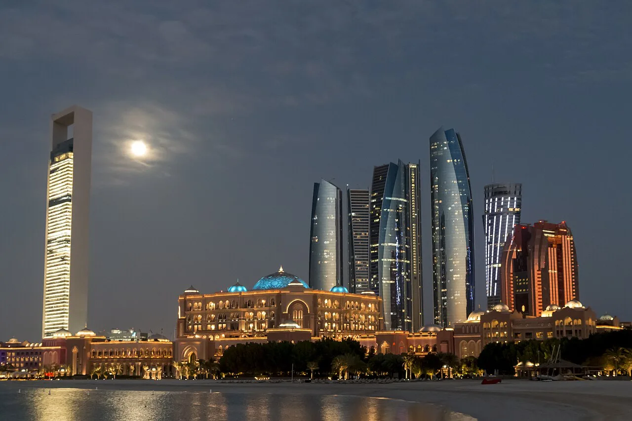 The Abu Dhabi skyline at night, representing sovereign capital and global investment in AI infrastructure.