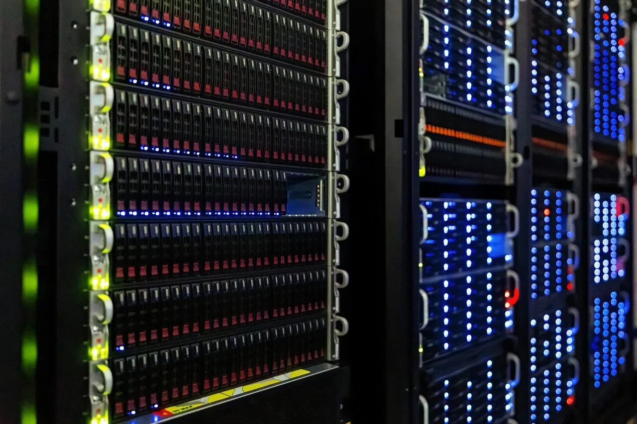 Close-up view of illuminated server racks in a data center, representing the compute infrastructure behind modern AI systems.