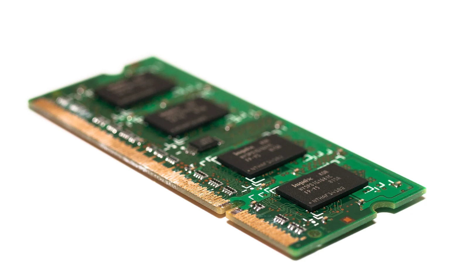 A green printed circuit board memory module, likely RAM.