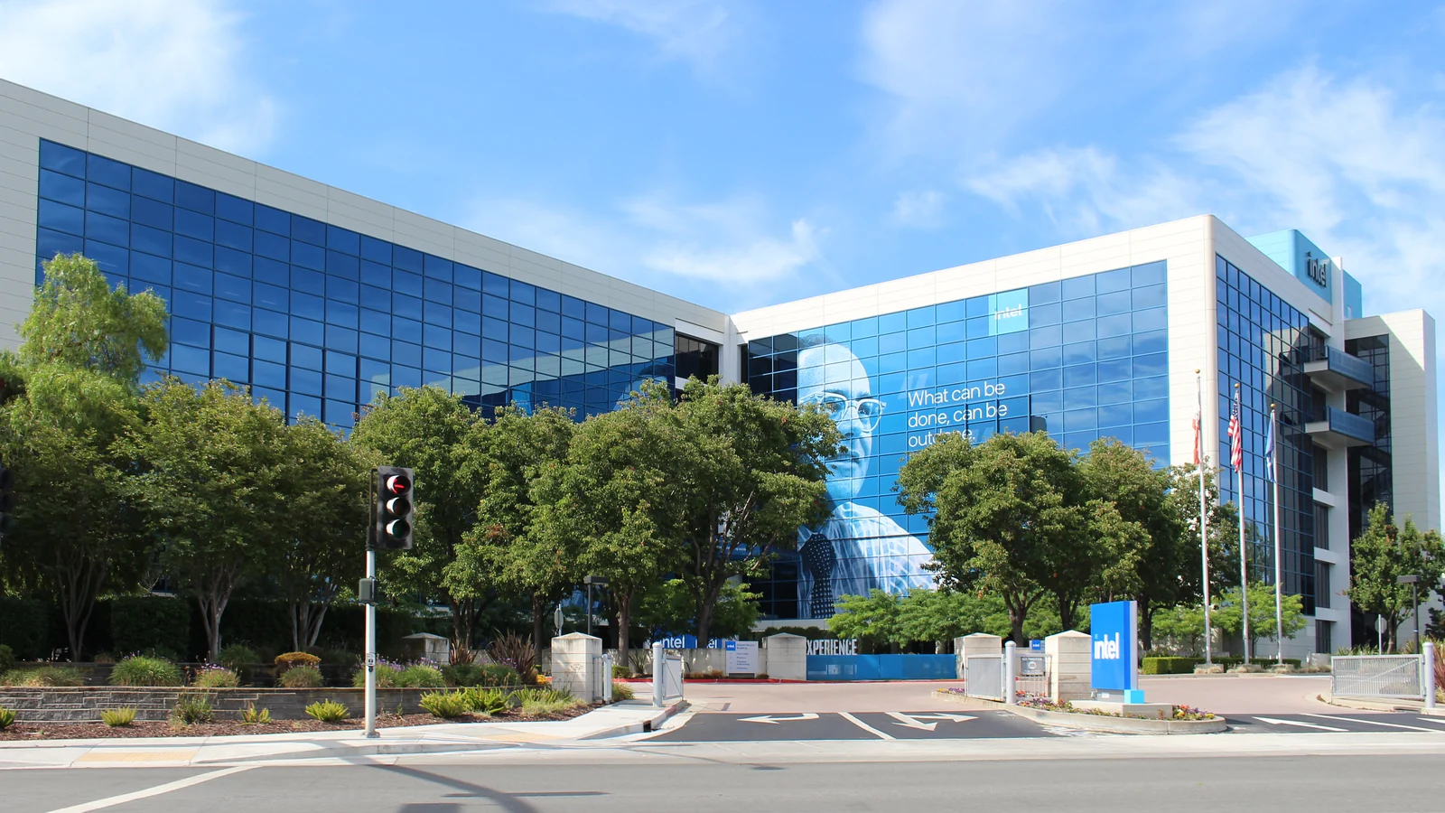 A large modern office complex with blue reflective glass walls, white paneling, and several connected wings.