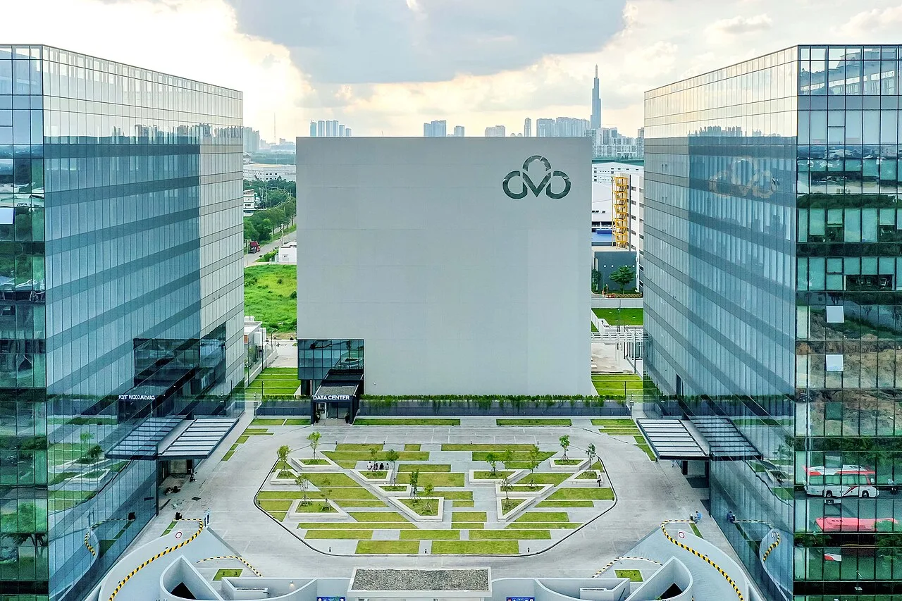 Exterior view of a modern glass-fronted data center campus, representing the physical infrastructure behind large-scale AI deployment.