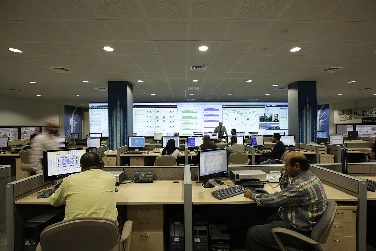A network operations centre with staff monitoring computer systems and infrastructure.